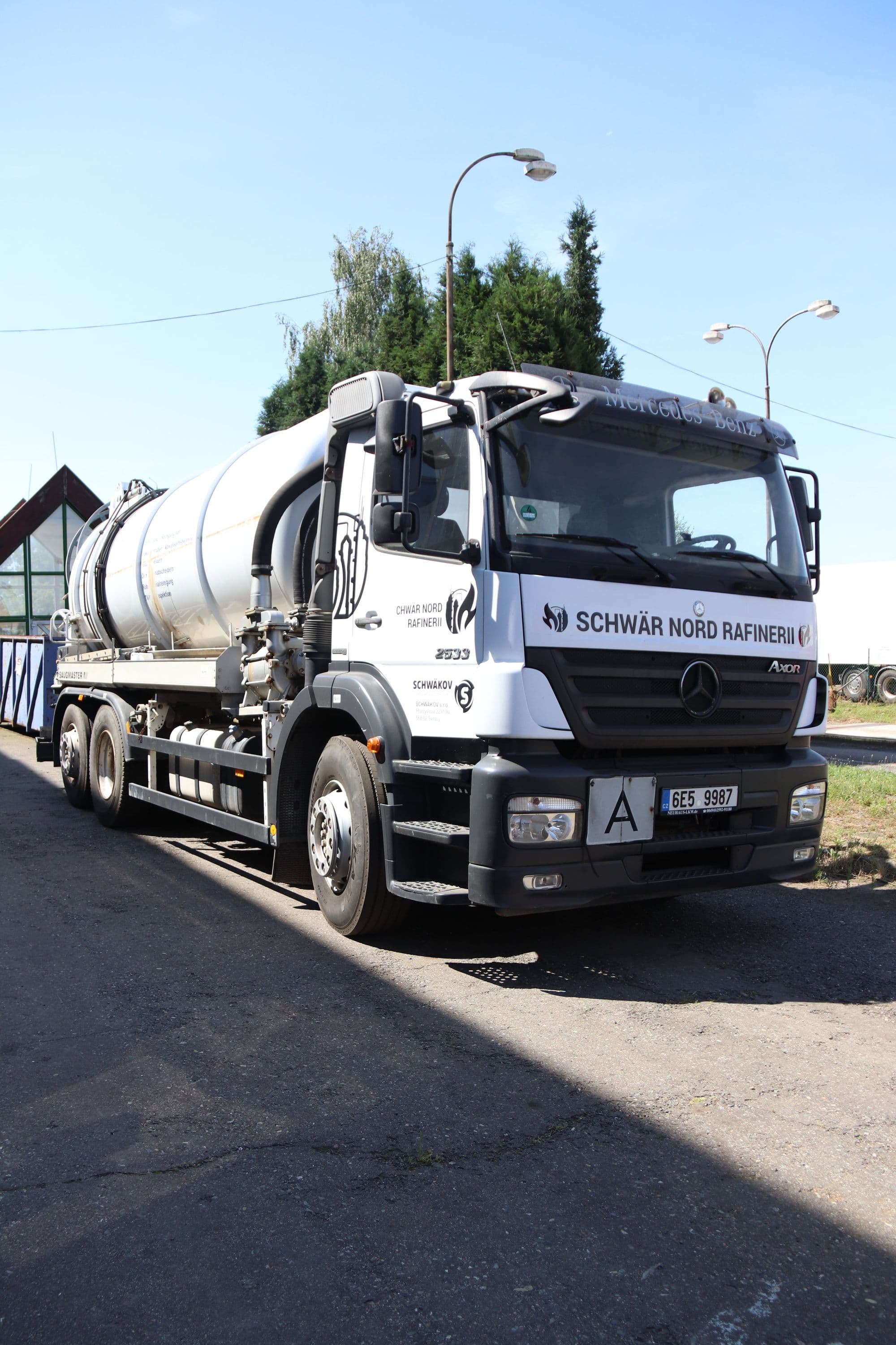 Bílý sací cisternový vůz Oil Master zaparkovaný u silnice