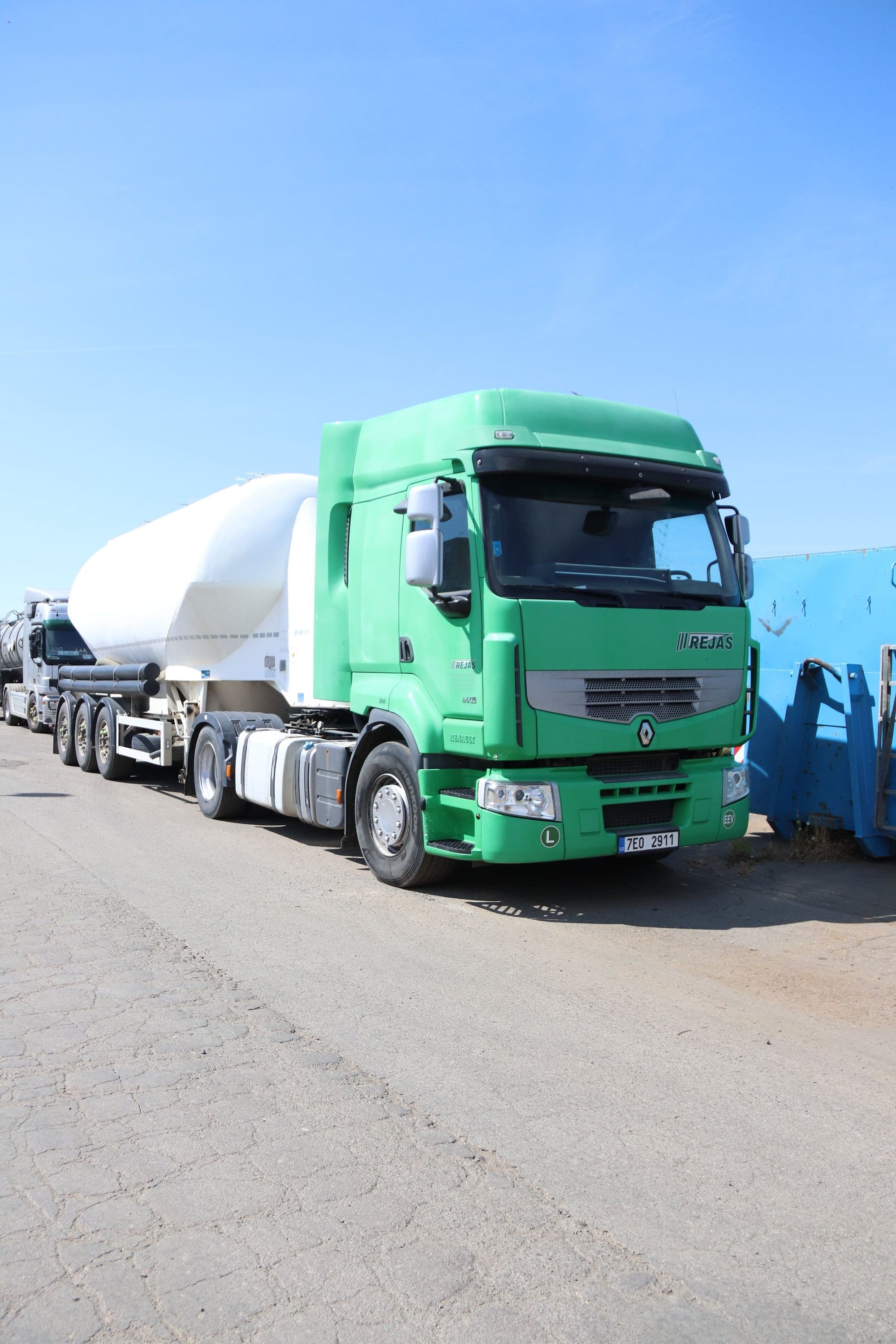 Zelený tahač se silo cisternou pro přepravu sypkých hmot